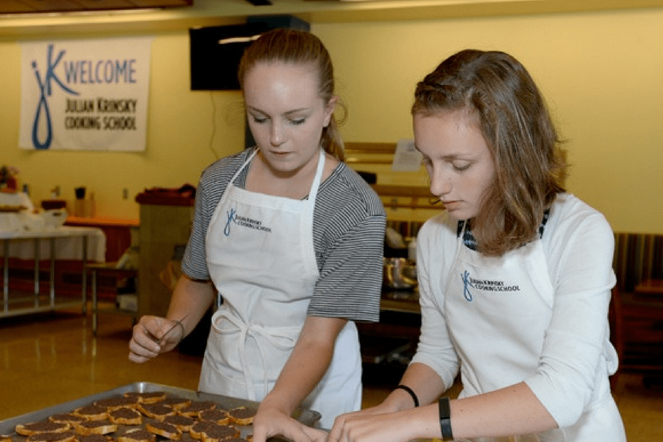 Three young students in cooking class wear aprons enjoyment while taking  selfie photo with mobile phone in kitchen, smiling and laughing, preparing  eggs and fruits, learn fun culinary course together. 7427729 Stock