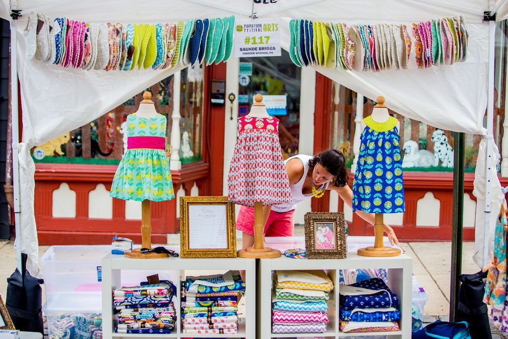 A clothing vendor sells her colorful wares at a Manayunk street festival. 