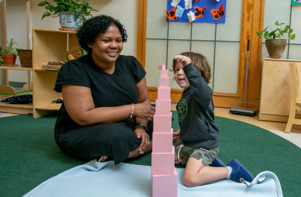 teacher and child building with blocks in a preschool classroom
