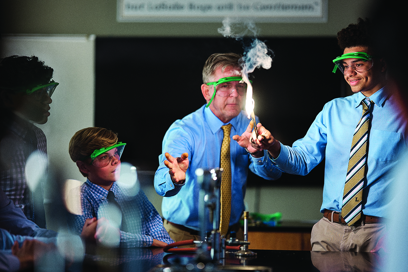 teacher and male students in a science laboratory