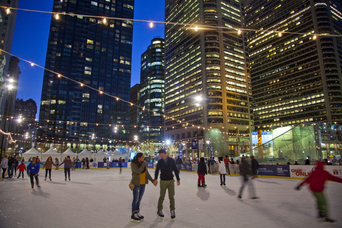 adults ice skating in the dark in a city