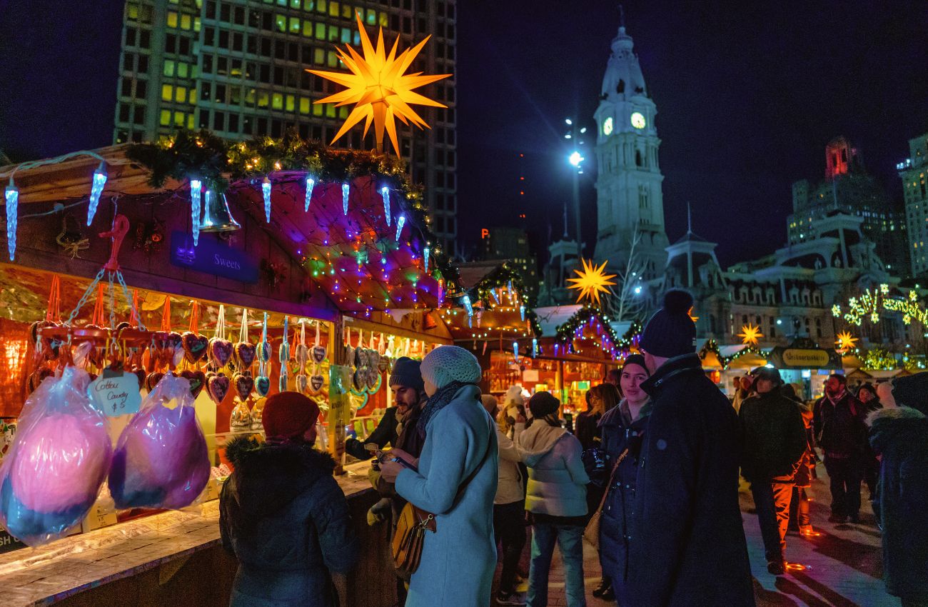 A glowing star hangs above vendor huts in Center City Philadelphia's outdoor holiday market, Christmas Village.