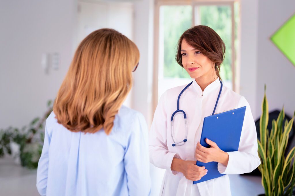 Female doctor consulting with her patinet at hospital corridor