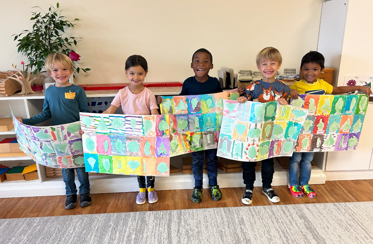 Young students standing in a row to show off their painting projects.