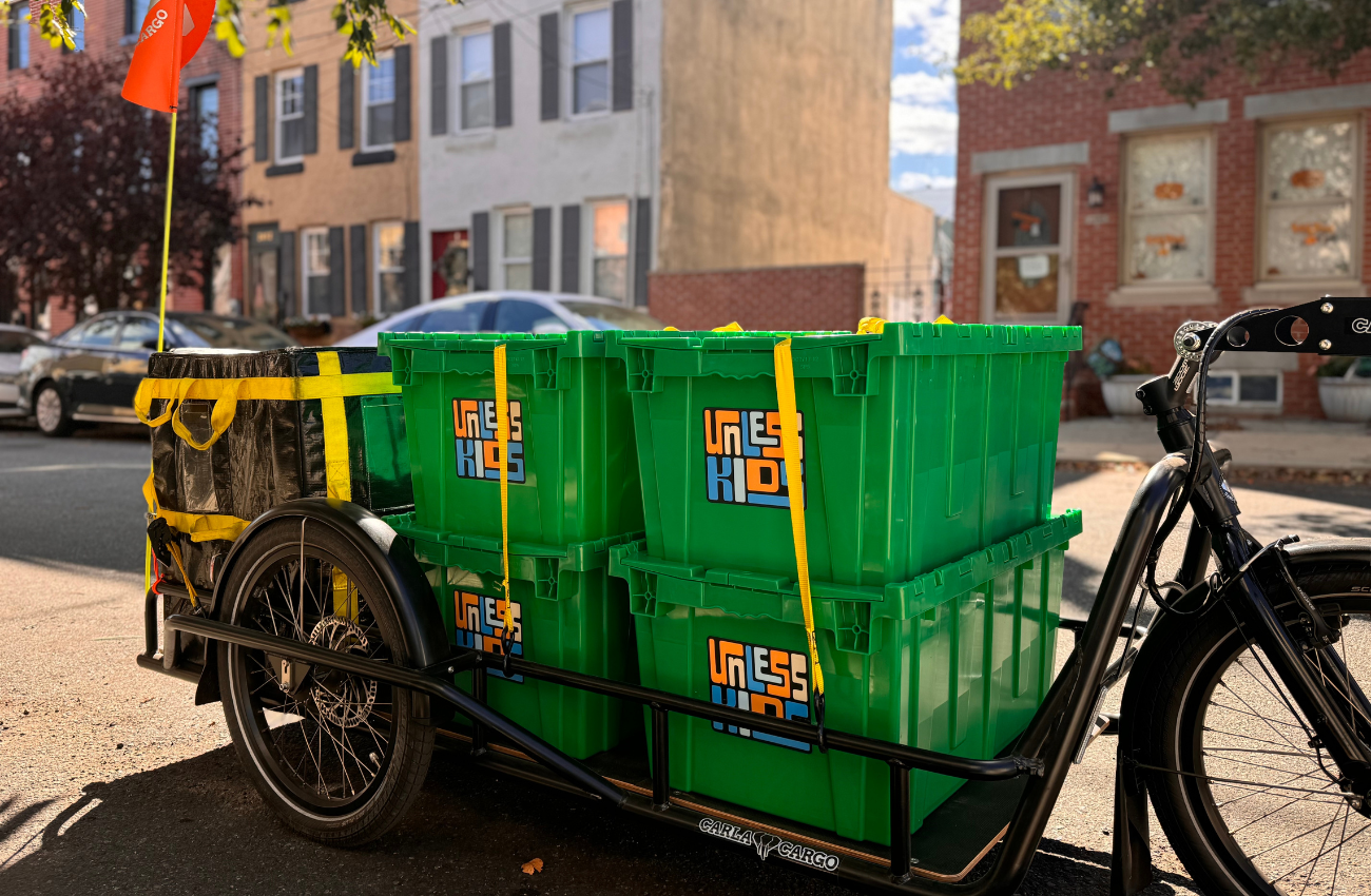 toy bins being pulled by a trailer hitched to a bike