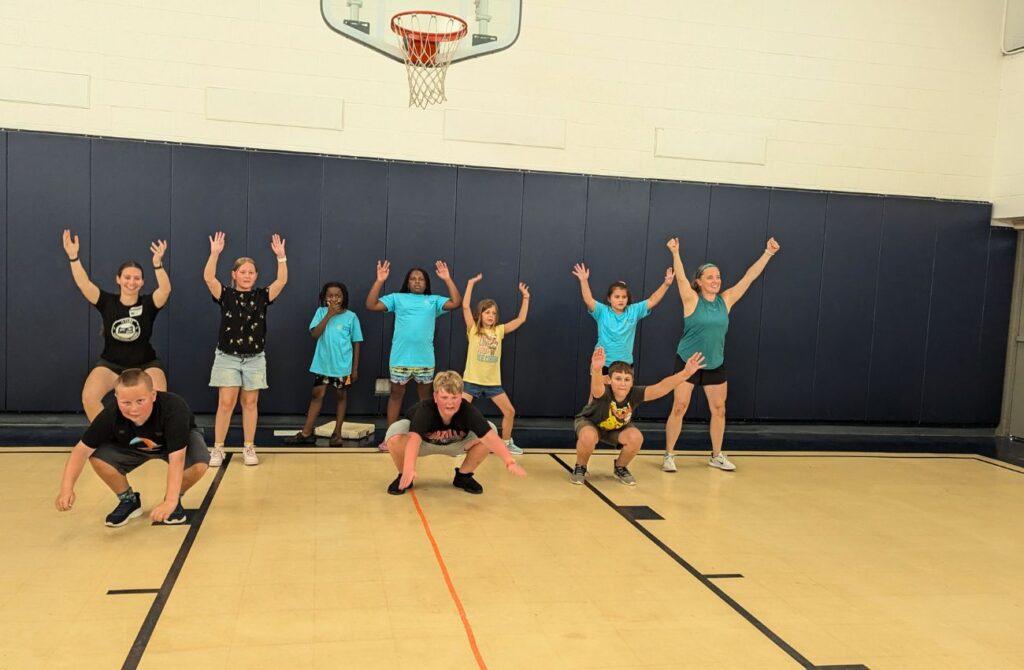 students in a gym class doing an exercise workout.