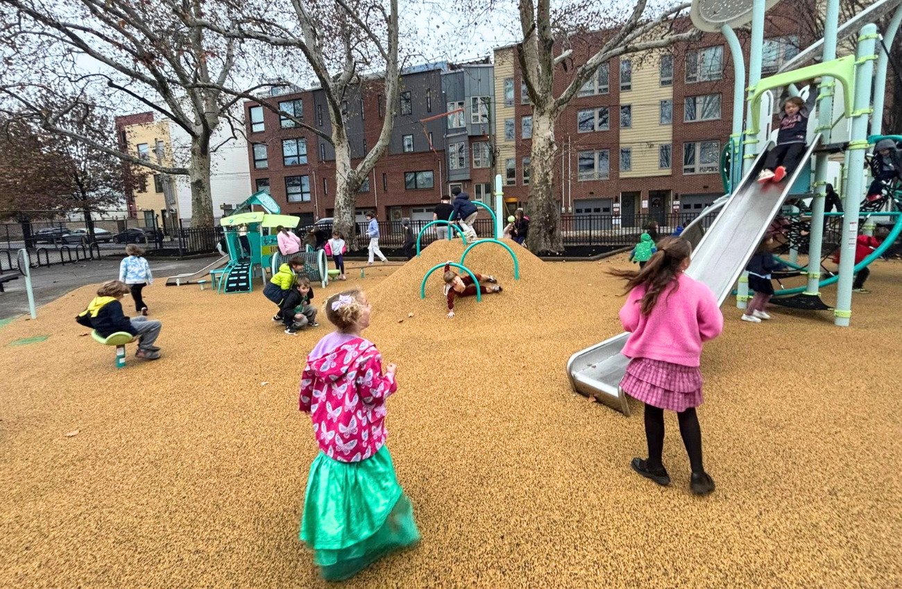 Kids run on the soft turf at the Shissler Recreation Center playground in Fishtown Philadelphia.