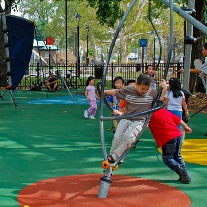 Kids play on play equipment and the soft turf at the Franklin Square playground.
