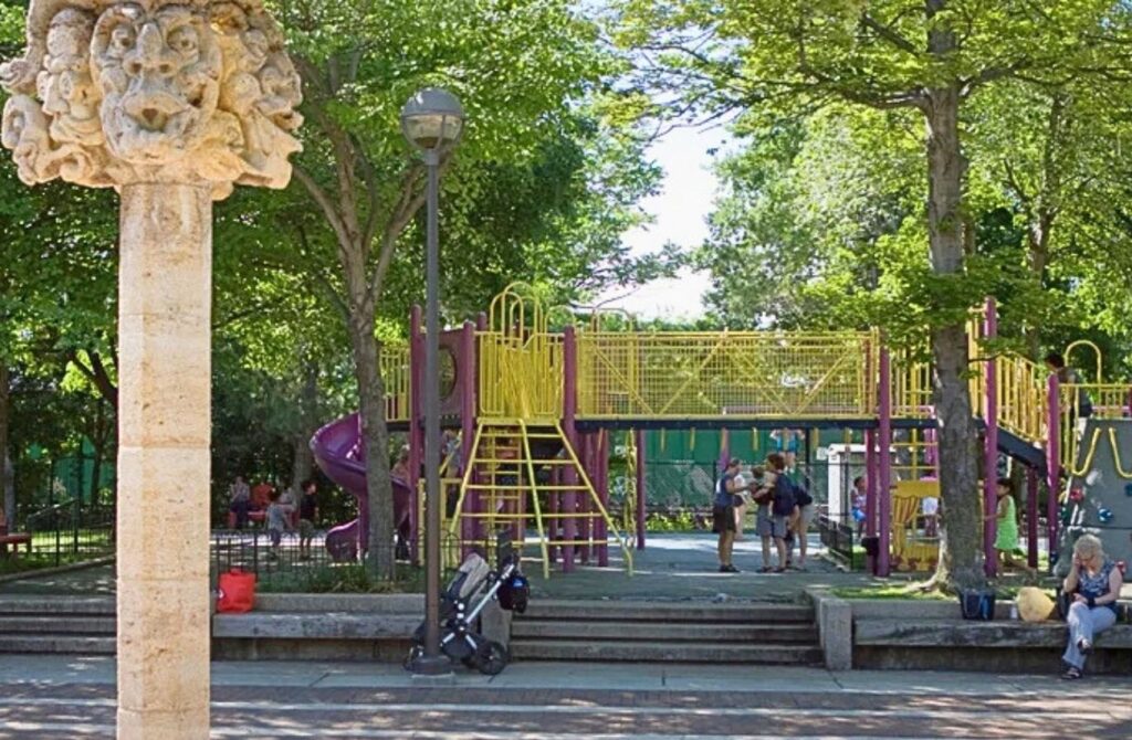 Trees grow around the expansive play structures and near the sculptural sprayer at Markward Playground.
