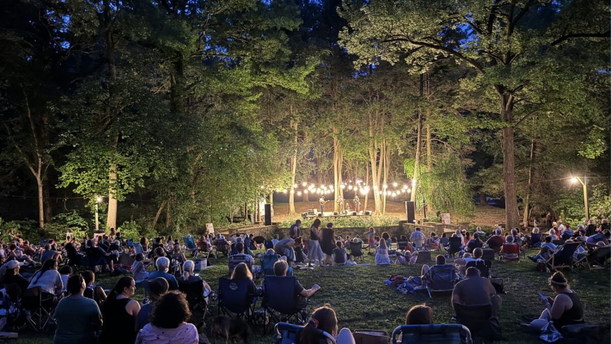Glowing lights in the trees at twilight during a Pastorius Park Summer Concert performance.