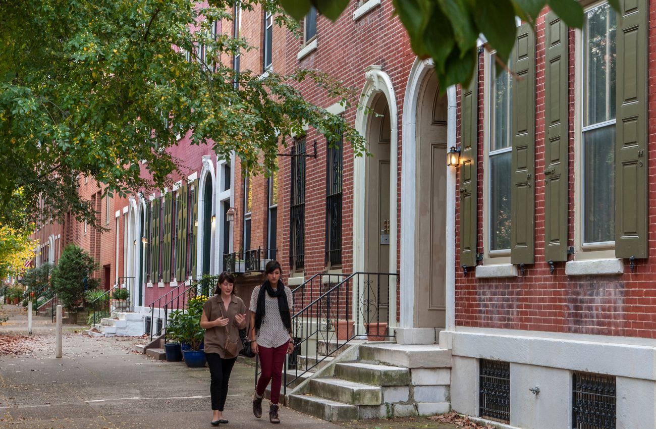 Two women stroll the tree-lined stretch of Spring Garden street in the Fairmount neighborhood in Philadelphia.