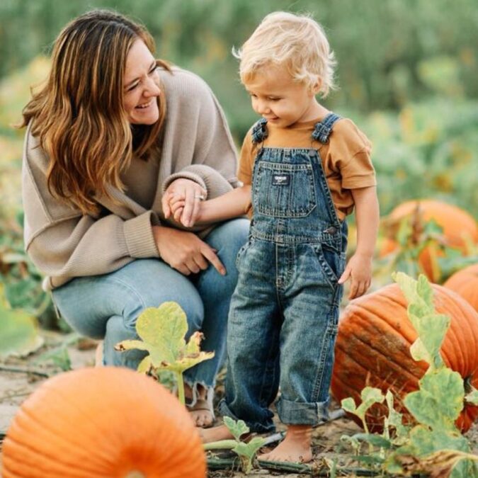A mother and toddler are pumpkin picking in a field at Johnson's Corner Farm in NJ.