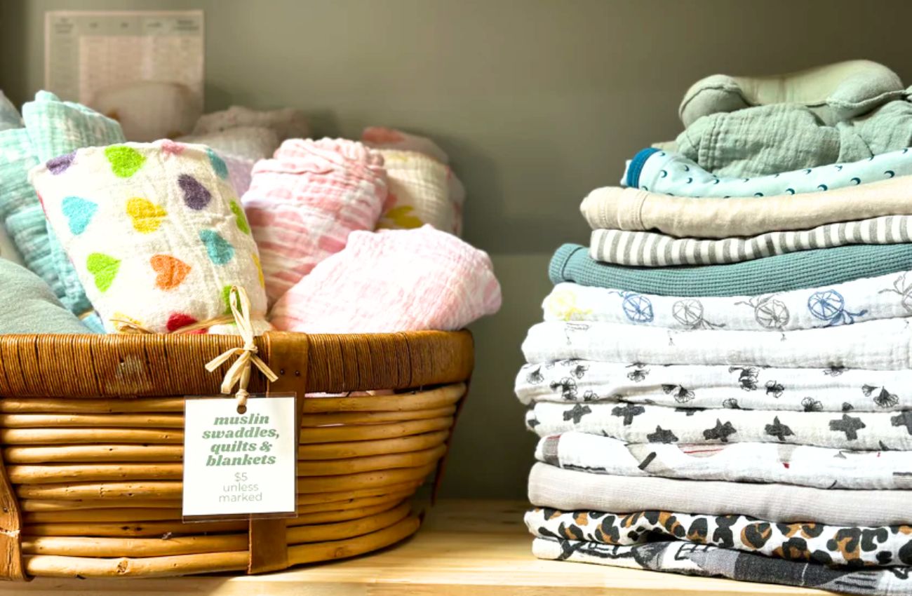A shelf at Nesting House holds fabric swaddlers for babies.