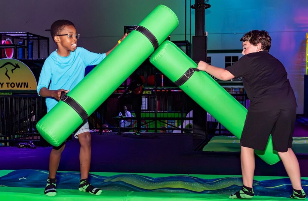 Two young boys battle with mat bats on a trampoline at Launch in Deptford, NJ.