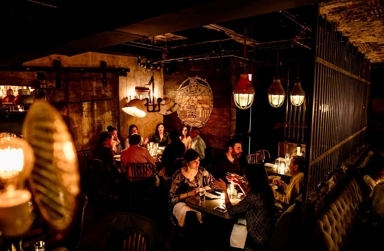 The cozy glow of low lamps glow in the dining room of Double Knot restaurant in Philadelphia.