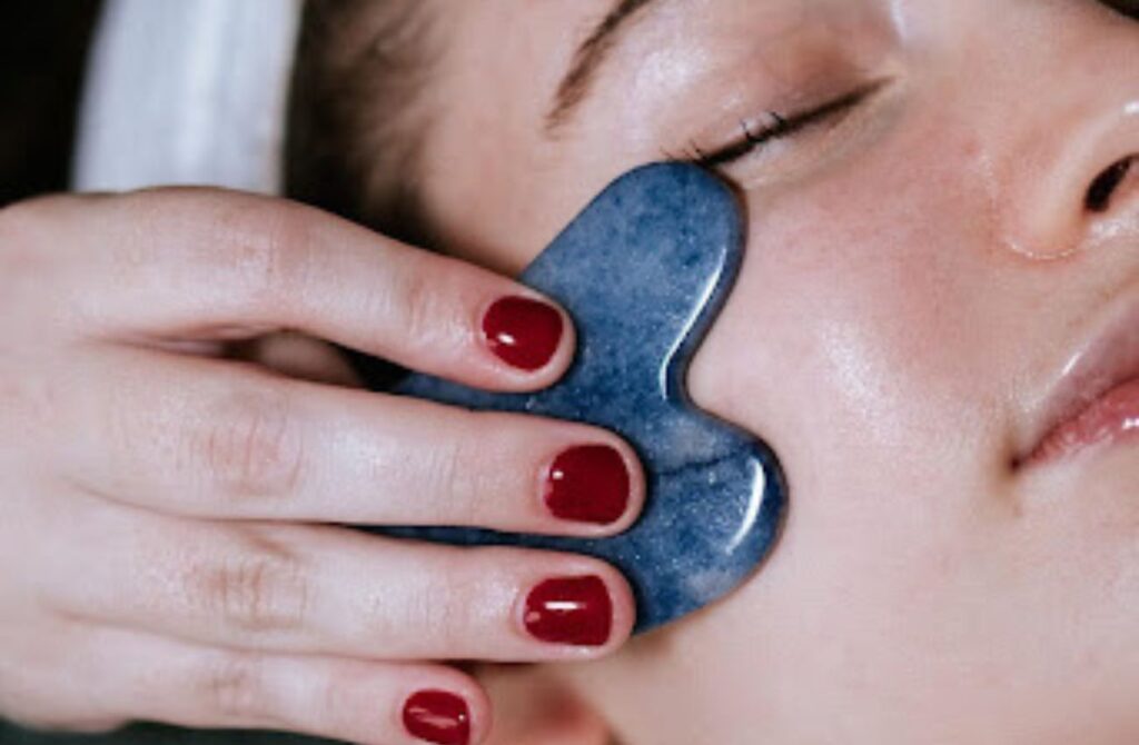 A woman receives a facial treatment using a smooth blue stone at Spa Hygge in Philadelphia. 
