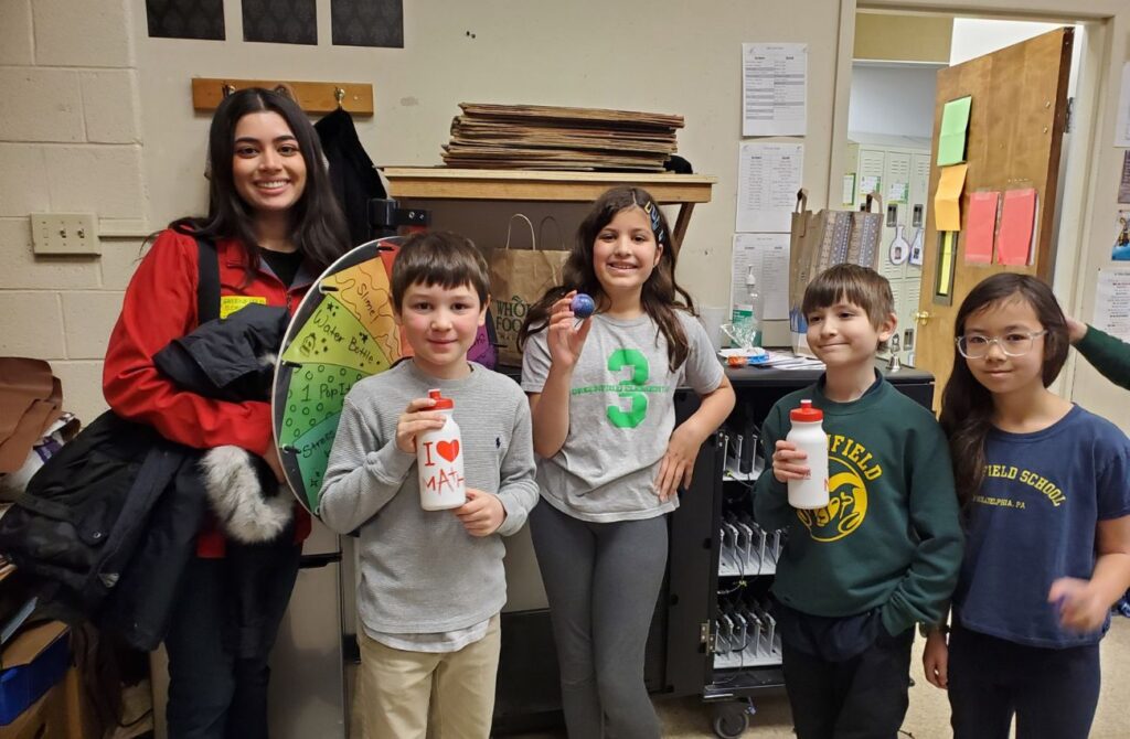 Four young students stand beside their Philly tutor at Mathnasium Center City. 