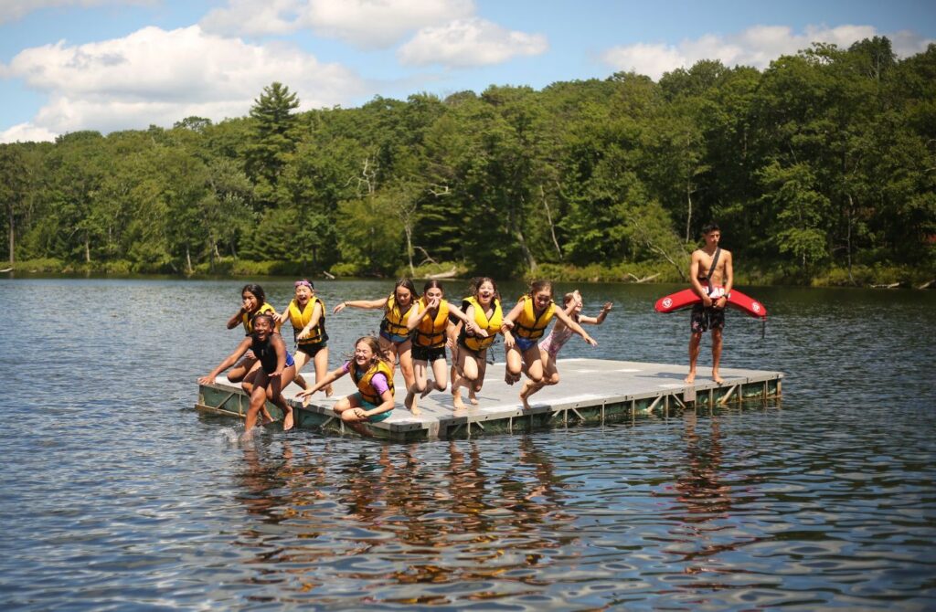 Campers jump off a float in the lake at Camp Speers YMCA. 