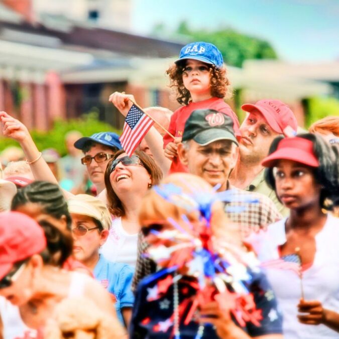 A crowd of patriotic citizens with American flags attend a July 4th event in Philadelphia.