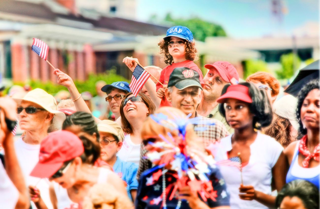 A crowd of patriotic citizens with American flags attend a July 4th event in Philadelphia.